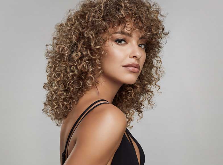 A woman with a curly balayage hairstyle