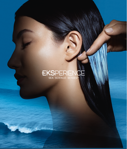 model using Eksperience hair products with the ocean in the background